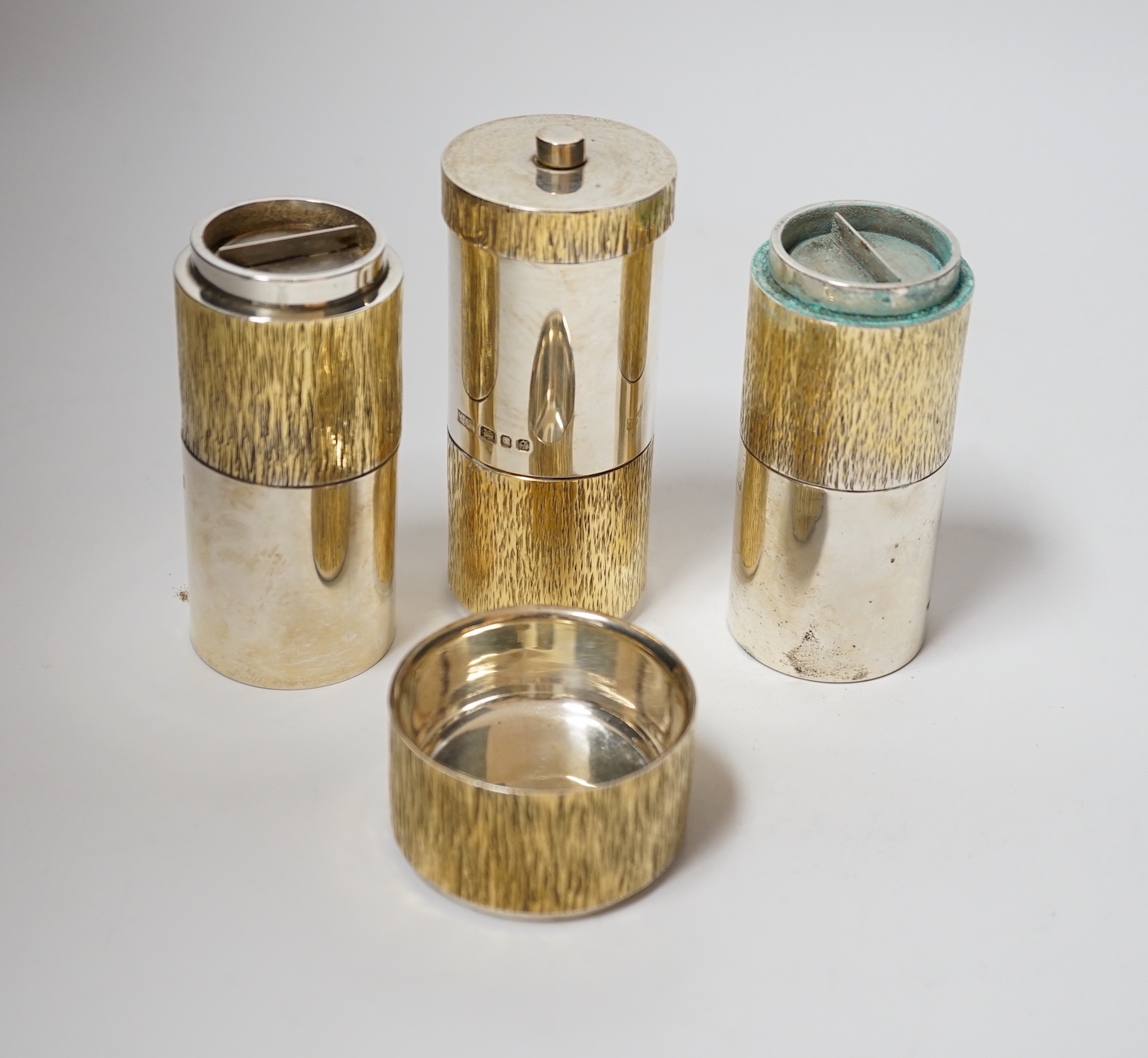 A suite of four Elizabeth II parcel gilt silver condiments, comprising a cylindrical salt, pepper and pepper grinder and a tub salt, Mappin & Webb, London, 1971, tallest 10.5cm.